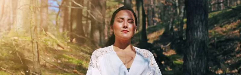 Forest bathing woman in the woods meditating